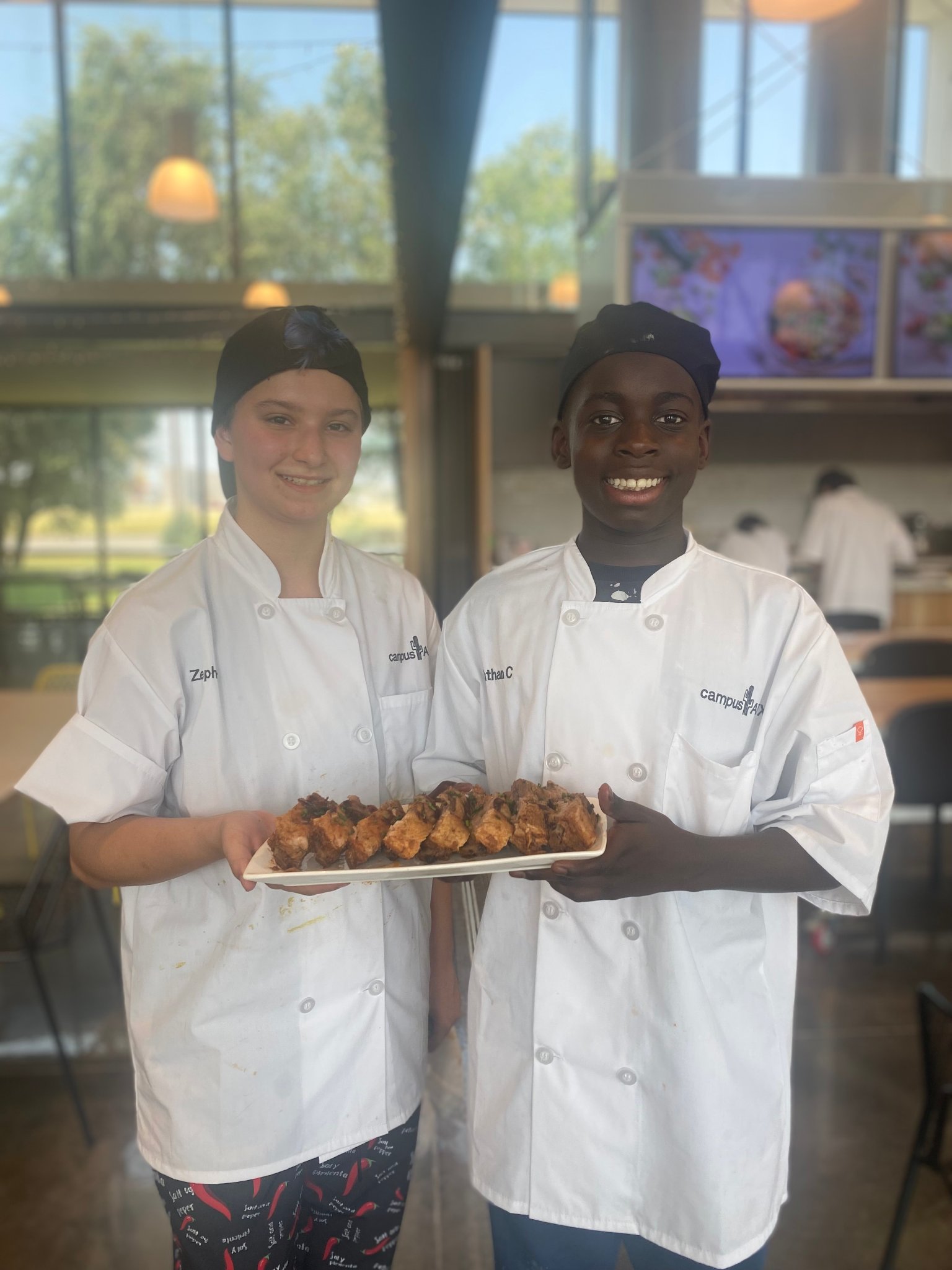 Teen campers proudly presenting their competition dishes